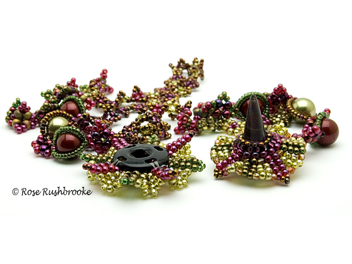 Opened snap clasp of burgundy and olive necklace by Rose C Rushbrooke. Beadweaving - glass spike bead, Swarovski crystals and pearls, and seed beads. Image copyright &copy; Rose Rushbrooke.