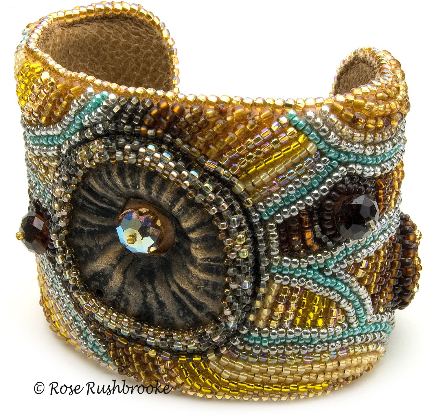 Inspired by a Bee cuff by Rose C Rushbrooke. Bead embroidery on a copper cuff. Bead embroidery on a copper cuff. Glass seed beads, polymer clay cabuchon, Czech glass beads, and crystals. Image copyright &copy; Rose C Rushbrooke.