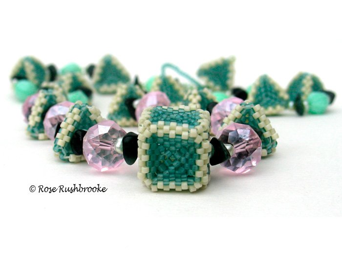 Triangles and Squares necklace by Rose C Rushbrooke. Seafoam and cream beaded beads, pale blue dyed pearls, green opal chips, pink rondelles glass beads, and mint pressed glass beads. Peyote stitch beadweaving. Image copyright &copy; Rose C Rushbrooke.