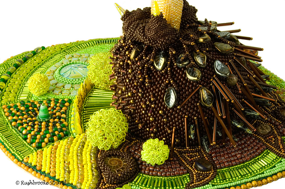 Close up 1 of Triffid - seed beads, crystals, Czech glass beads, ceramic focal, ammonites, and selected beads. Peyote stitch beadweaving, bead embroidery. BeadDreams 2018 finalist. Image copyright &copy; Rose Rushbrooke.